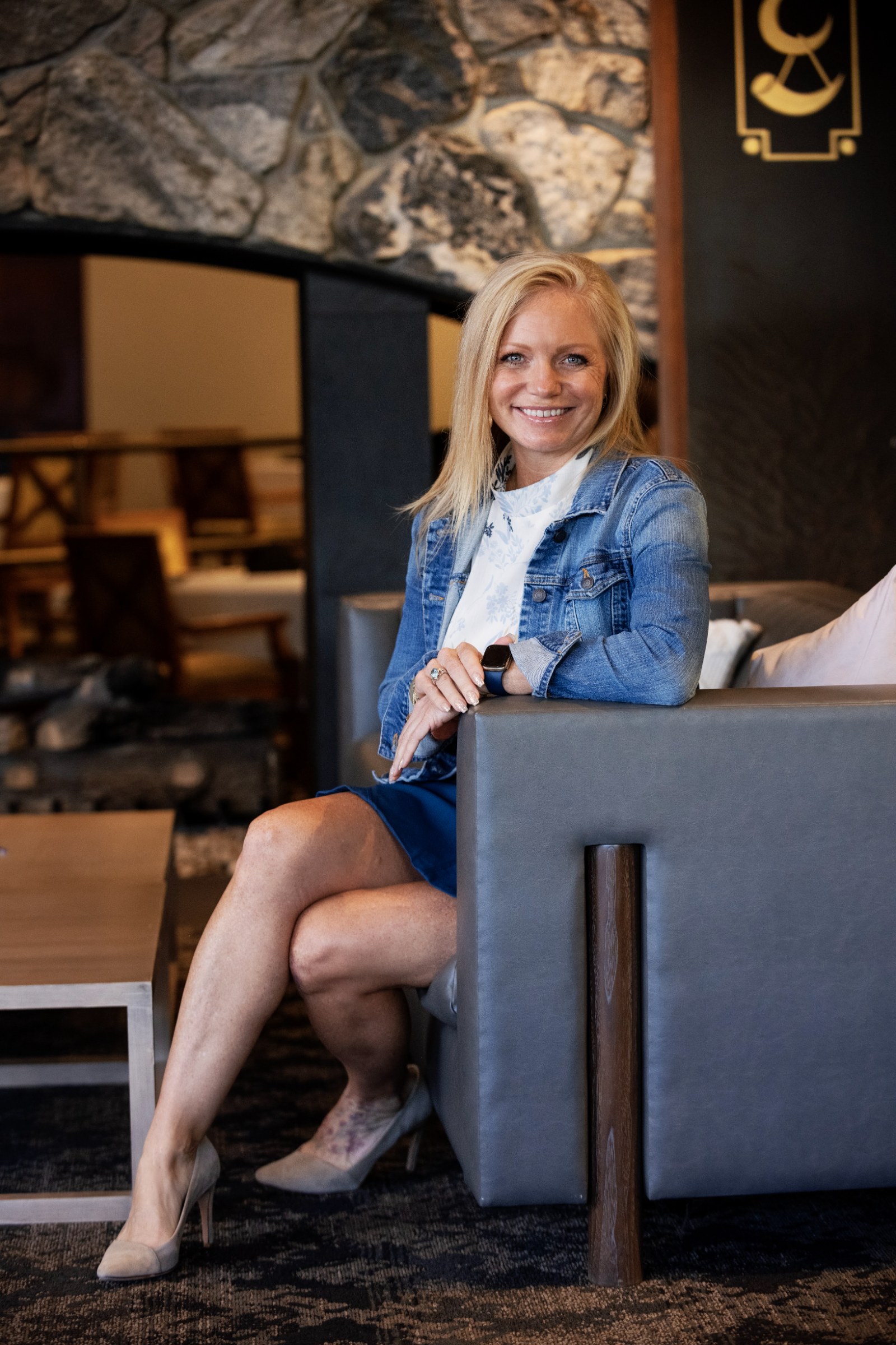 Denise Jensen seated by a fireplace in a warm room