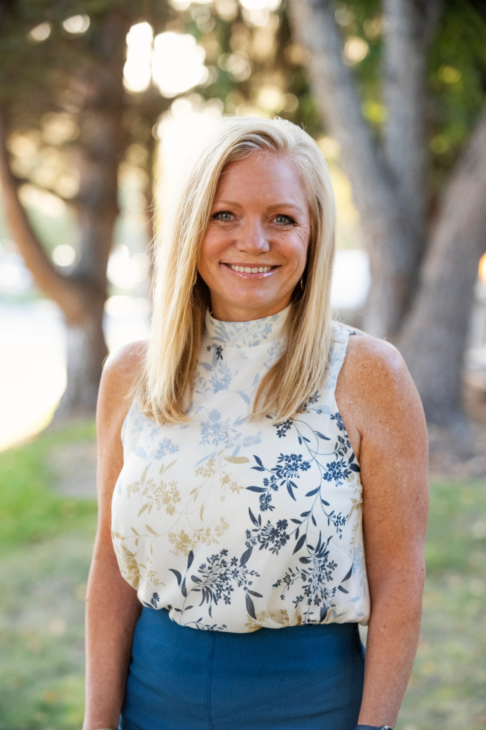 Denise Jensen, LMSW, smiling among trees in Boise